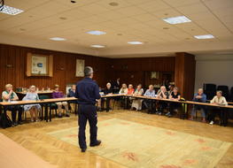 policjant rozmawia z seniorami w budynku UM Zakopane